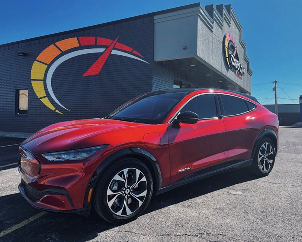 Red car infront of turbo tint building and signage with window tint on all windows