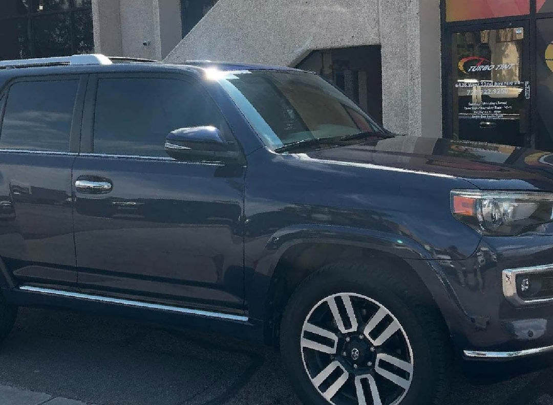 Dark windo tint on a black Sedan infront of turbo tint Arvada