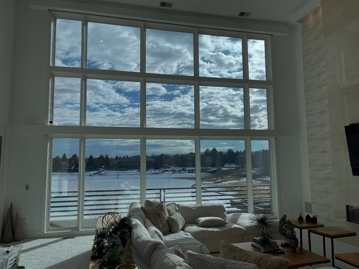 Living room with large windows showing a snowy landscape tinted with Turbo Tint for no need of blinds or curtains 