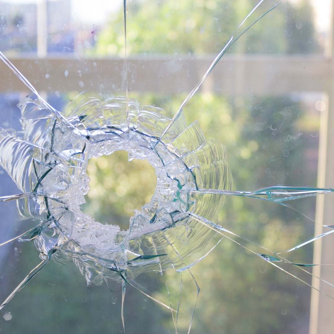 broken glass from storm held together by clear window tint for protection 